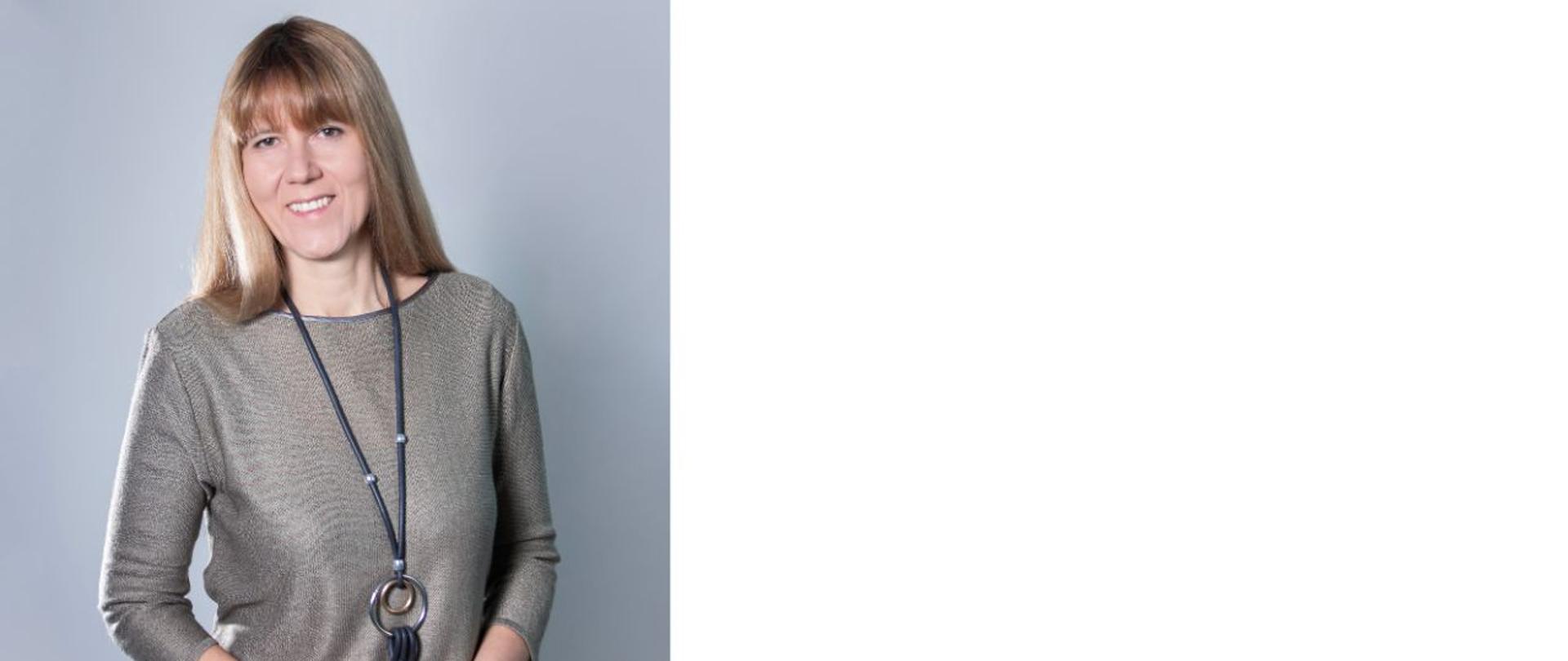 Elegancko ubrana kobieta uśmiecha się do zdjęcia+