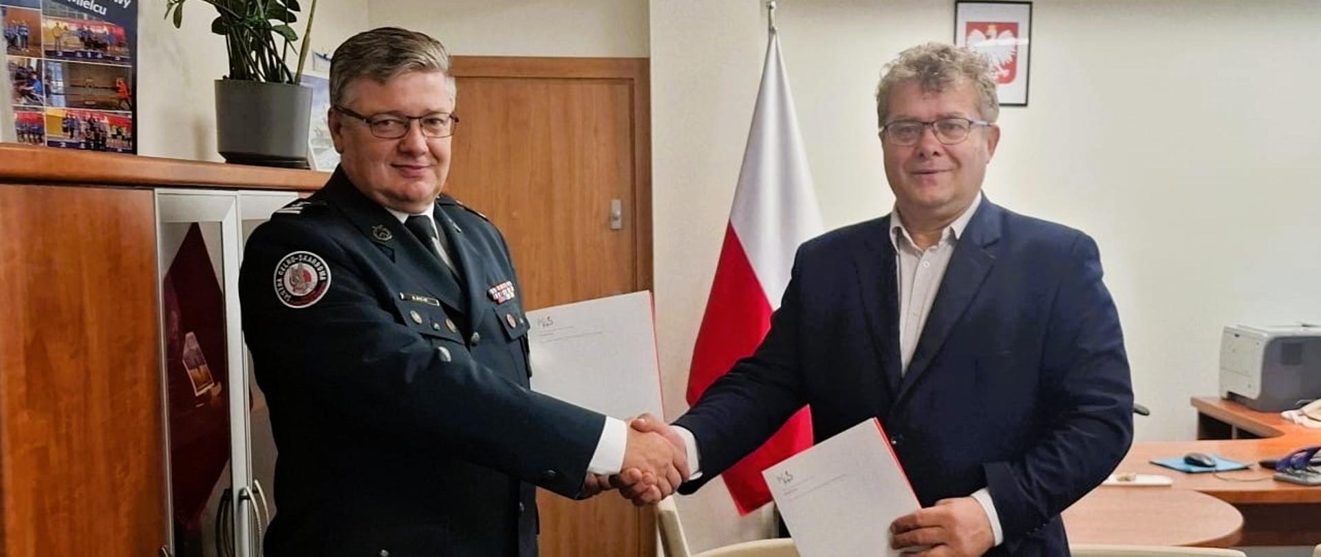 Dyrektor Izby Administracji Skarbowej w Rzeszowie oraz Starosta Powiatu Mieleckiego, reprezentujący Powiat Mielecki podają sobie rękę.