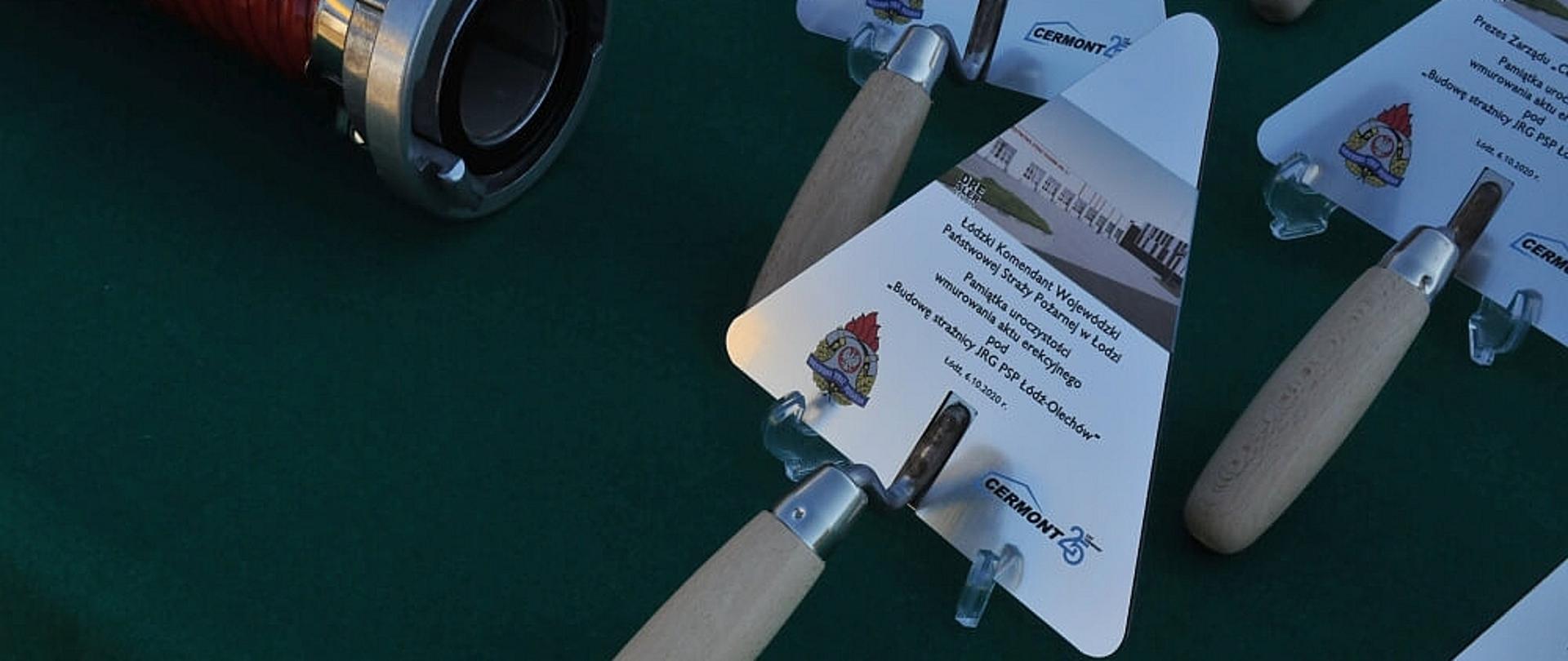 fragment stołu na którym znajdują się pamiątkowe kielnie