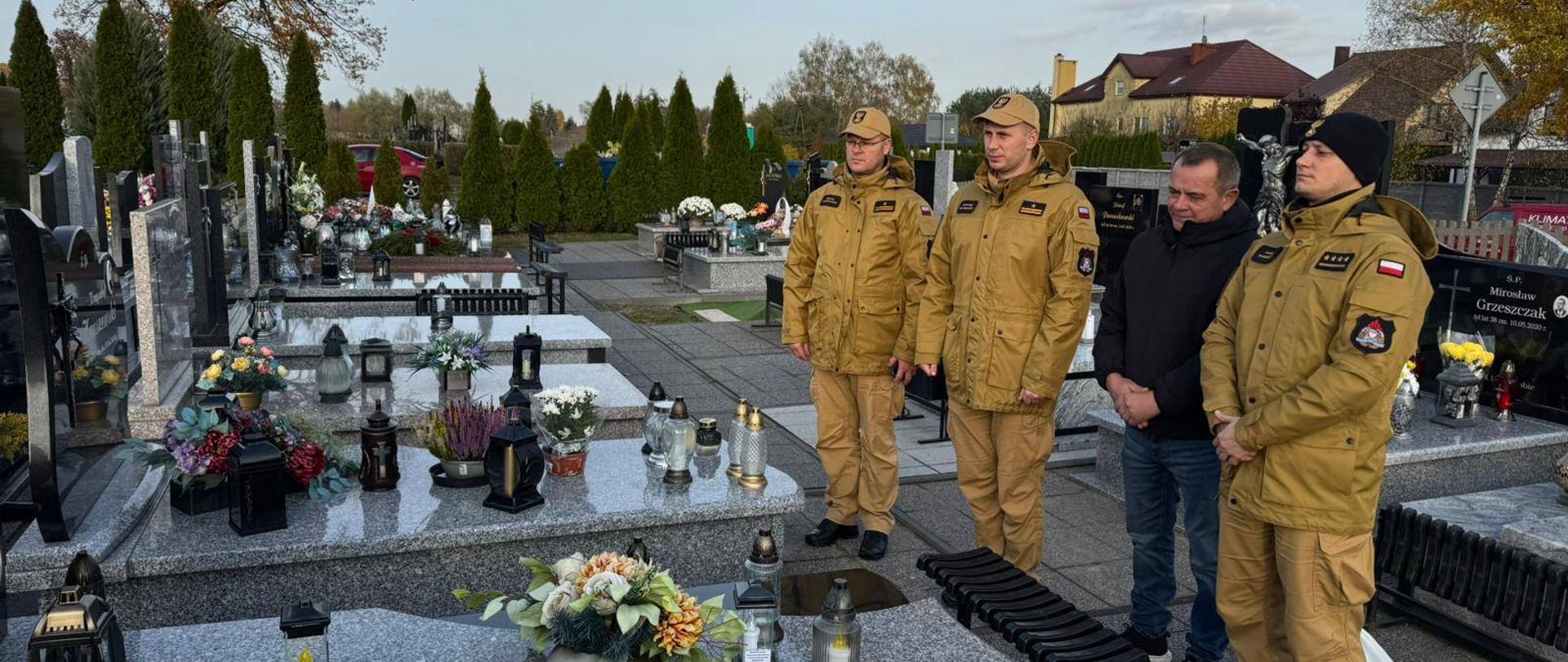 Delegacja z KP PSP w Makowie Mazowieckim oddaje hołd zmarłemu strażakowi przy pomniku na cmentarzu.
