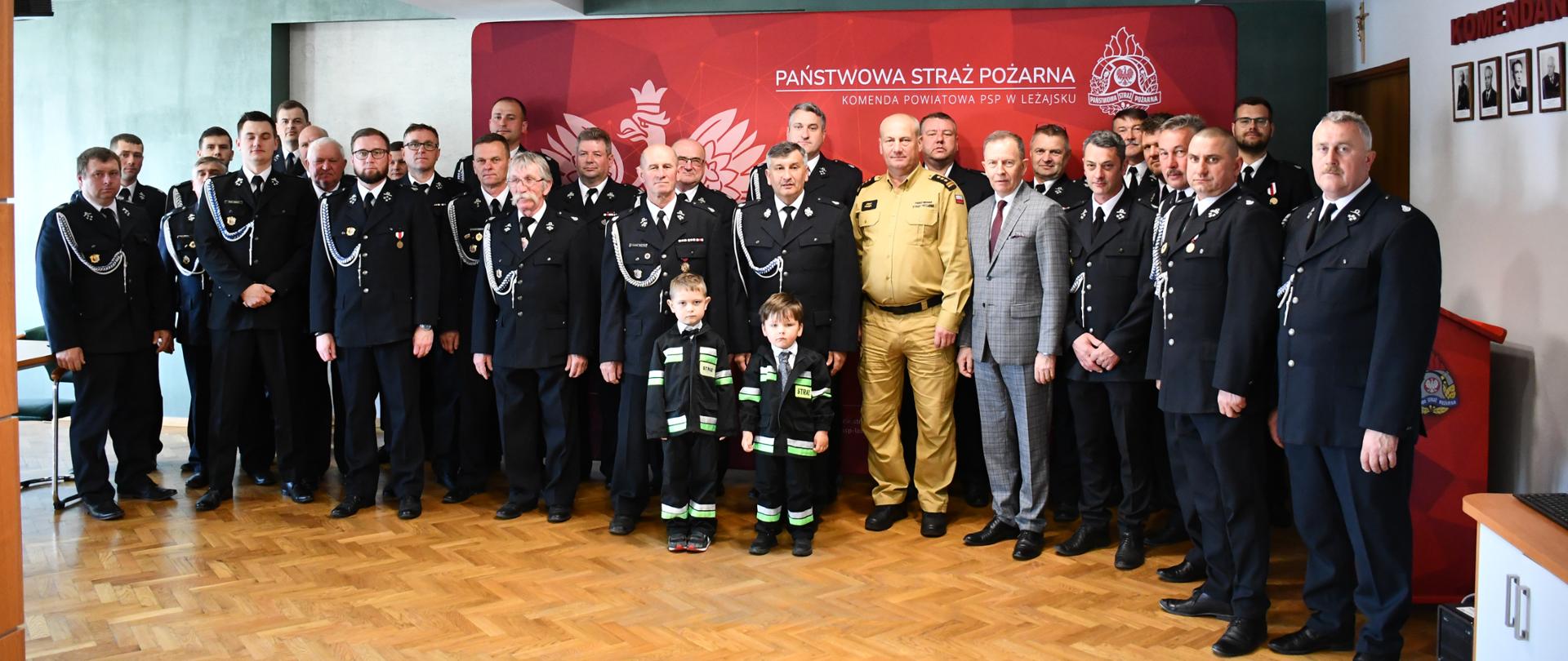 Na zdjęciu widzimy Wiceprezesa Wojewódzkiego Funduszu Ochrony Środowiska i Gospodarki Wodnej w Rzeszowie Pana Bogusława Kidę, Posła na Sejm RP Pana Jerzego Paula, Komendanta Powiatowego Państwowej Straży Pożarnej w Leżajsku Pana starszego brygadiera Józefa Kludysa oraz strażaków z Ochotniczych Straży Pożarnych pozujących do zdjęcia zbiorowego.