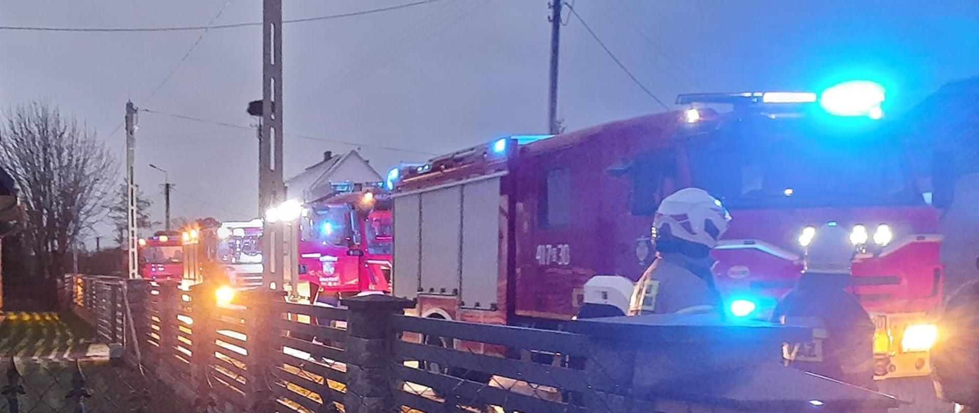 Samochody ratowniczo-gaśnicze z włączonymi sygnałami świetlnymi biorące udział w zdarzeniu. 