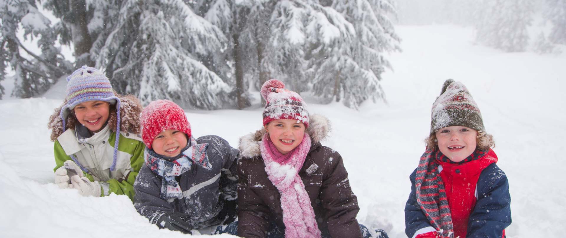 dzieci na śniegu, w czapkach, szalikach usmiechnięte