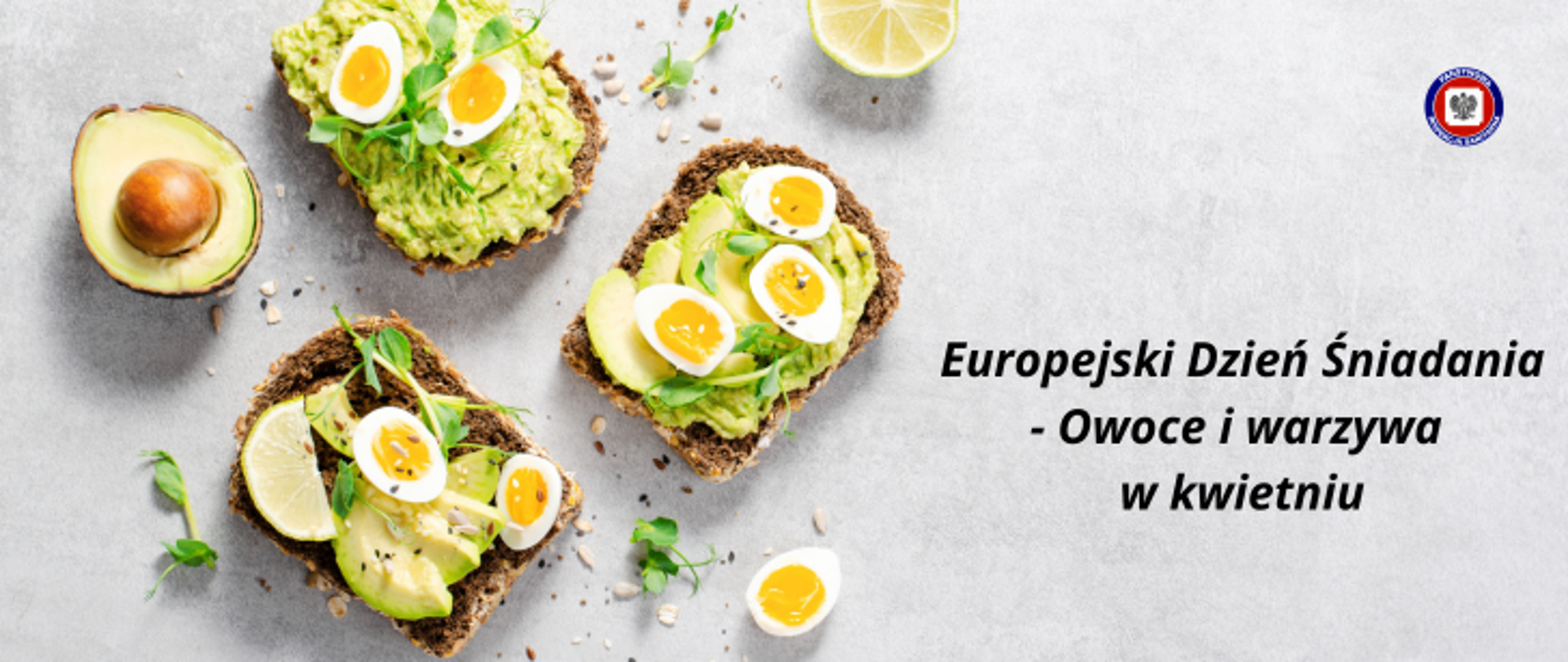 Na jasnoszarym, betonowym tle, po lewej znajdują się trzy kromki chleba z pastą awokado, jajkiem i przyprawami, po lewej ciemny napis Europejski Dzień Śniadania - owoce i warzywa w kwietniu. W prawym górnym rogu logo Państwowej Inspekcji Sanitarnej.
