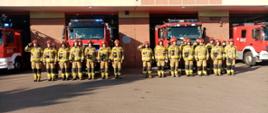 Minuta ciszy dla poległych strażaków z Ukrainy. Strażacy przed KM PSP w Łomży oddają hołd poległym strażakom na Ukrainie stojąc na baczność. Dowódca salutuje.