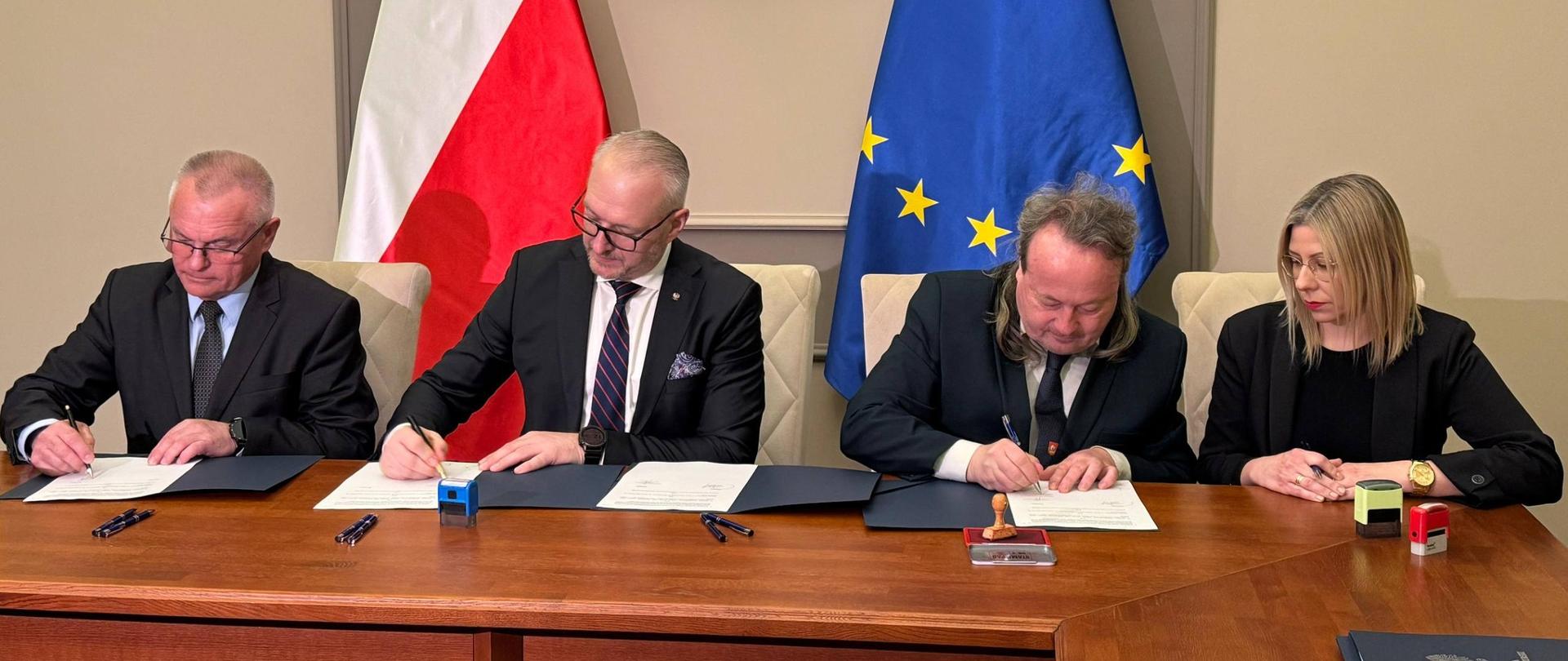 Elegancko ubrani ludzie siedzą przy stole, podpisują umowy 