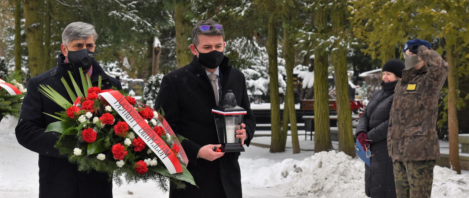 Dyrektor generalny LUW z dyrektorem biura wojewody składają wiązankę i znicz
