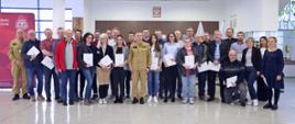 Pamiątkowe zdjęcie grupowe uczestników szkolenia aktualizującego inspektorów ochrony przeciwpożarowej (27 osób) w towarzystwie Zastępcy Komendanta Centralnej Szkoły PSP, kobiety oraz funkcjonariusza CS PSP