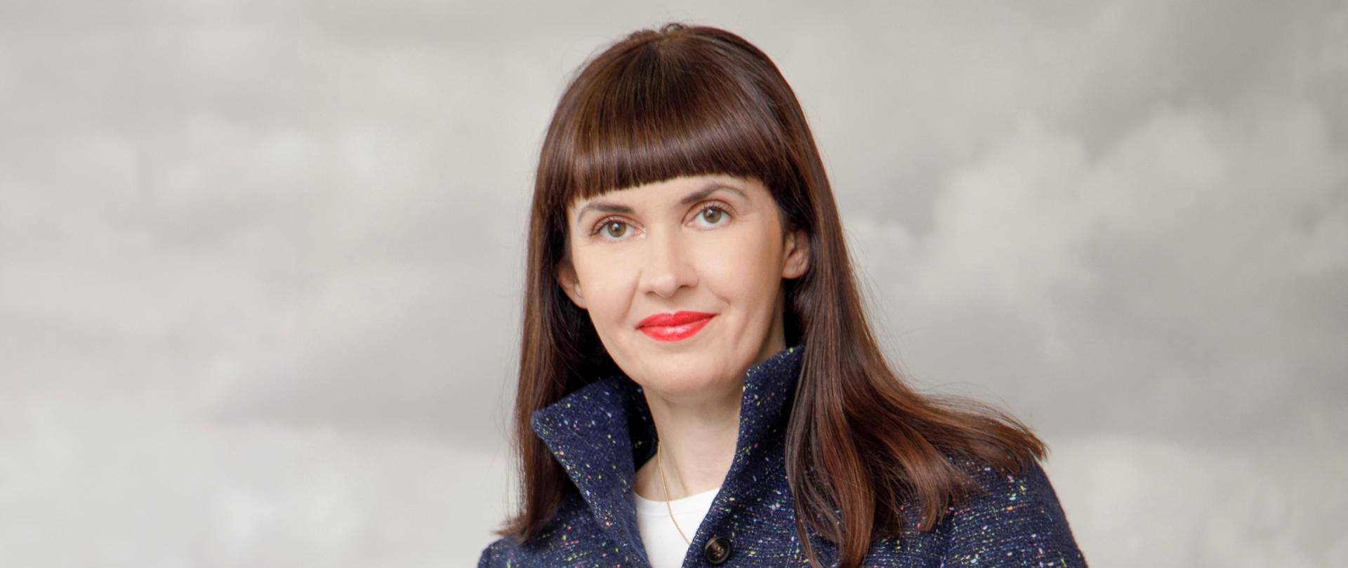 A woman in a jacket and dark pants
