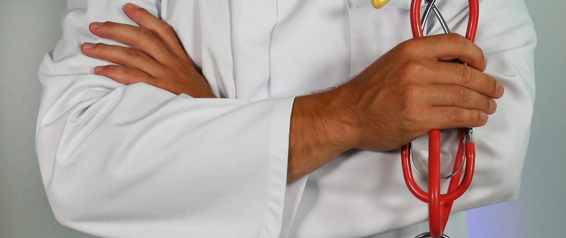 Sylwetka lekarza ze stetoskopem w ręku.