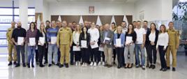 Grupowe zdjęcie uczestników szkolenia (30 osób) w towarzystwie Zastępcy Komendanta Centralnej Szkoły PSP, dwóch funkcjonariuszy CS PSP oraz kobiety