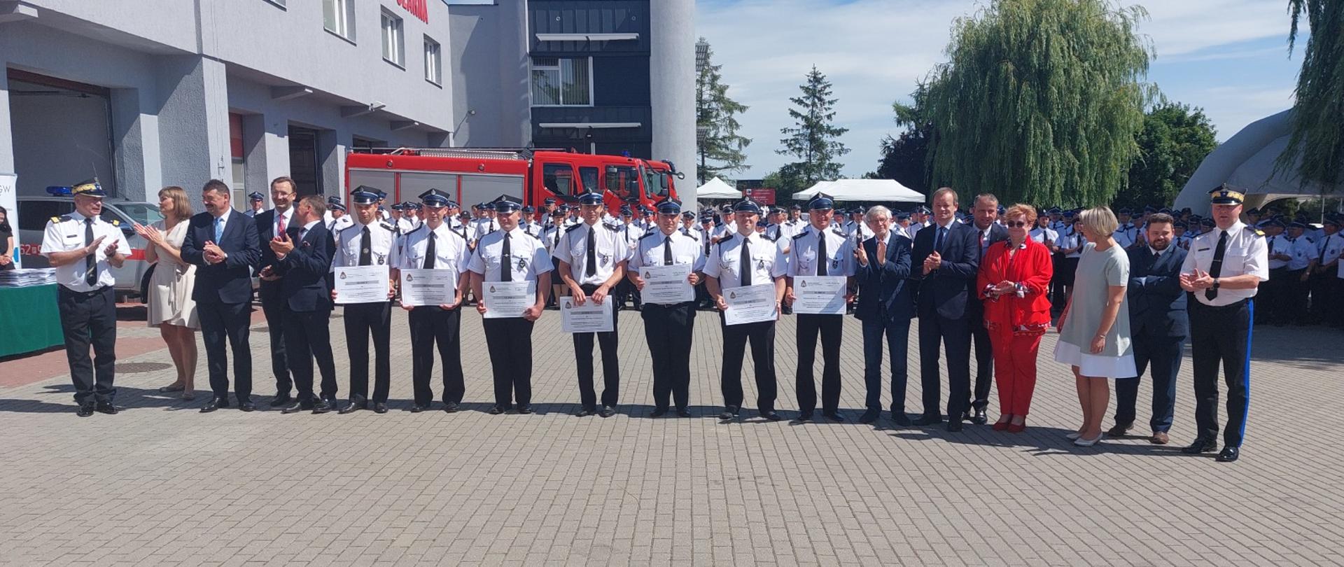 Zdjęcie grupowe na którym stoją od lewej zastępca KG PSP, posłowie dalej druhowie posłowie prezes WFOŚ oraz WKW PSP 