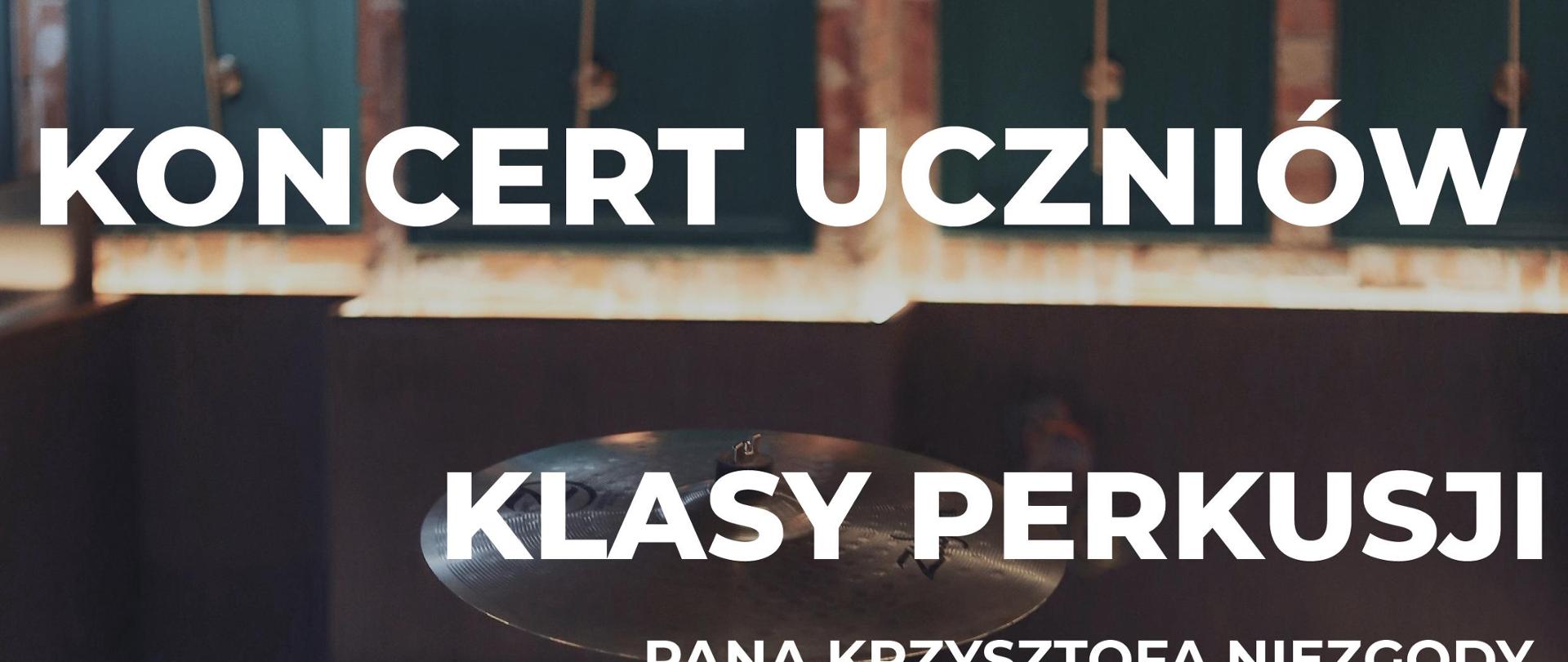 Plakat w ciemnym kolorze. W tle instrument perkusyjny. Informacja o wydarzeniu w kolorze białym. 