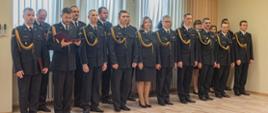 Na zdjęciu widoczny spiker uroczystości mł. bryg. Dominik Jeleń, stojący wraz z funkcjonariuszami tutejszej komendy.