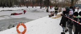 Strażacy podczas prezentacji ćwiczeń lodowych przed dziećmi 