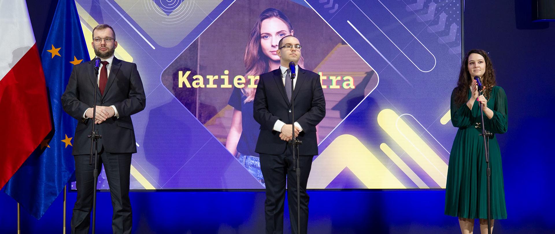 Minister Piotr Mazurek na inauguracji największego w Polsce programu szkoleniowo-stażowego, wraz z Ministrem Funduszy i Polityki Regionalnej Grzegorzem Pudą oraz Pełnomocnik Prezesa Rady Ministrów ds. GovTech, Pełnomocnik Ministra Edukacji ds. Transformacji Cyfrowej Justyną Orłowską