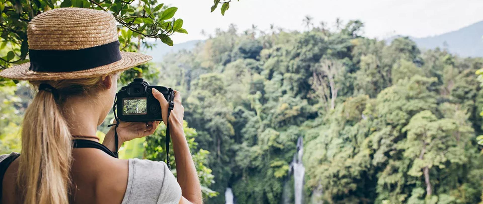 Młoda kobieta jako turystka robi zdjęcia lasu tropikalnego