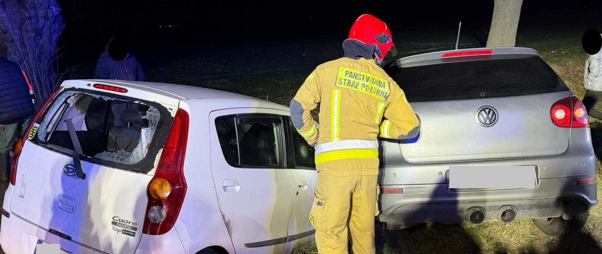 Samochody w rowie,, strażak przy samochodzie, noc