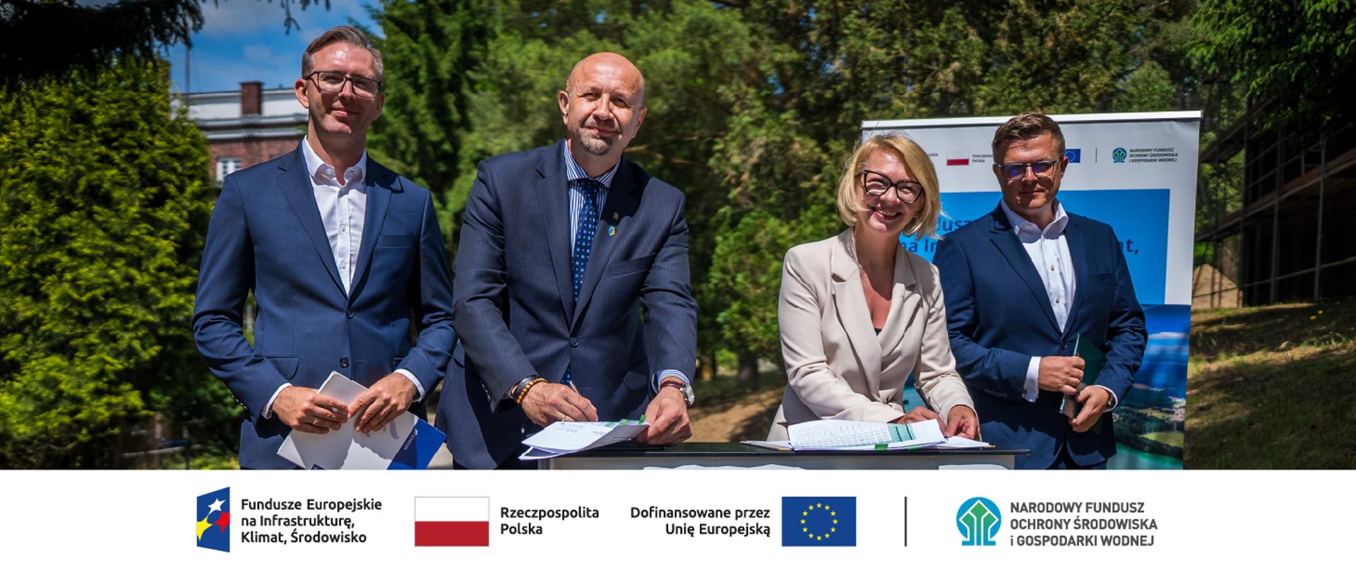 Robert Gajda, Zastępca Prezesa Zarządu NFOŚiGW podczas podpisywania umowy. W stopce grafiki ciąg logotypów: Fundusze Europejskie na Infrastrukturę, Klimat, Środowisko, flaga Rzeczypospolita Polska, flaga UE i Dofinansowane przez UE, NFOŚiGW.