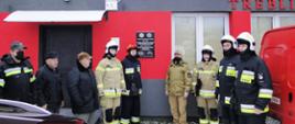 Wizyta Zastępcy MKW PSP. Strażacy stoją przed budynek strażnicy OSP.