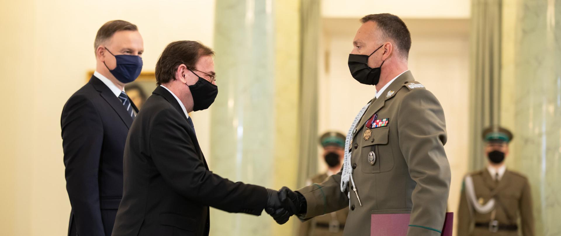 Minister MSWiA składa gratulacje jednemu z awansowanych oficerów. Na zdjęciu jest również Prezydent RP.