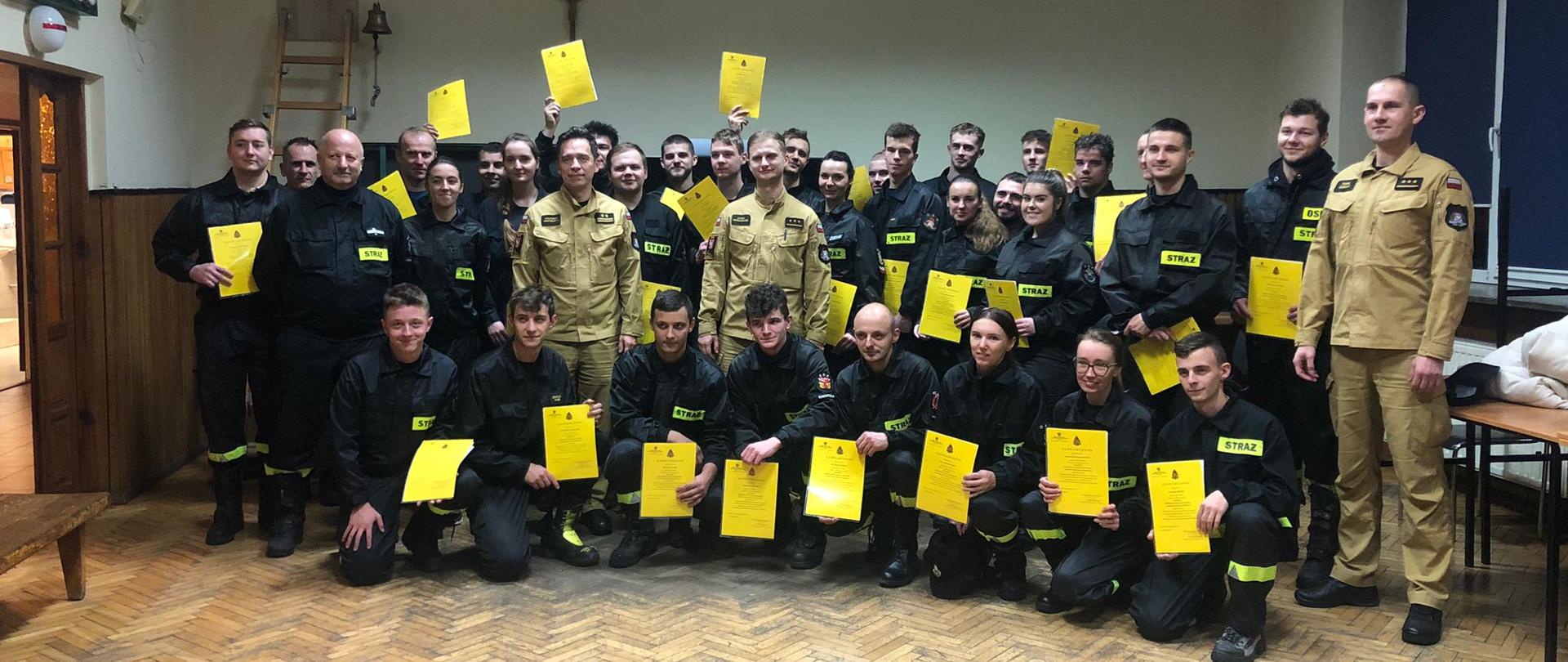 Słuchacze wraz z zastępcą komendanta powiatowego PSP w Wadowicach oraz komisją egzaminacyjną po rozdaniu świadectw