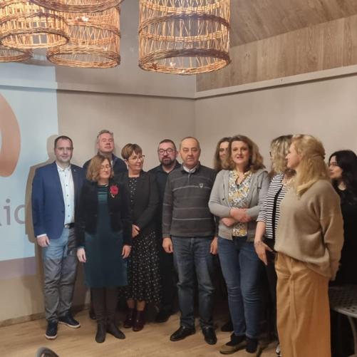 Zdjęcie przedstawia grupę osób pozujących do zdjęcia na tle logo Polish aid