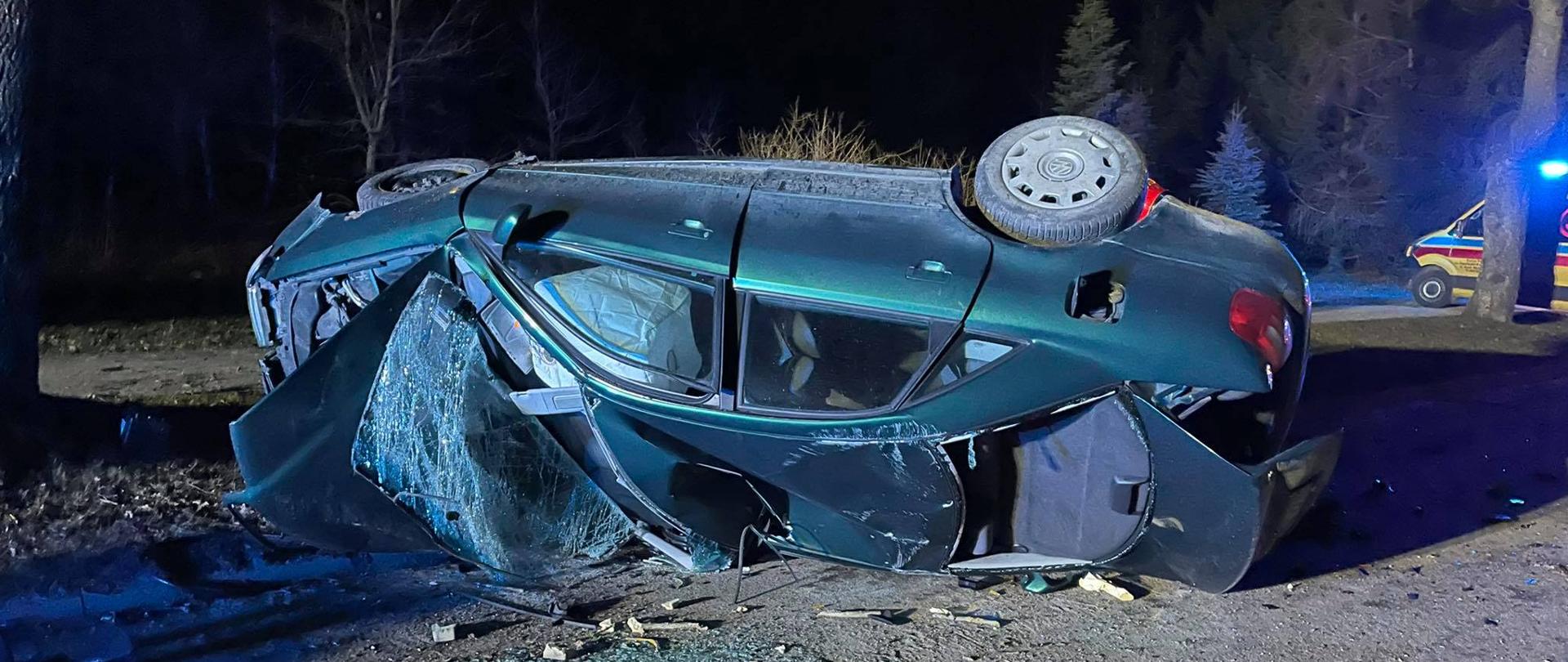 Na zdjęciu widać samochód osobowy audi leżący na lewym boku