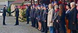 Funkcjonariusz prowadzący uroczystość melduje pomorskiemu komendantowi wojewódzkiemu Państwowej Straży Pożarnej zakończenie uroczystości poprzez uścisk dłoni. Obok na tle zabytkowych samochodów gaśniczych stoją funkcjonariusze oraz pracownicy cywilni Komendy Wojewódzkiej Państwowej Straży Pożarnej.