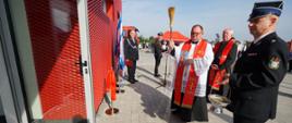 Zdjęcie przedstawia księdza, który święci nowy budynek remizy OSP