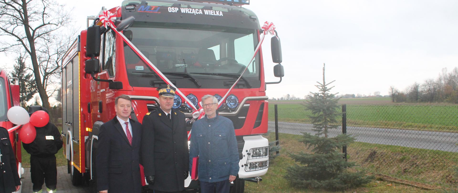 Zdjęcie przedstawia posłów na sejm RP Leszka Galembę, Witolda Czarneckiego i nadbryg. Dariusza Matczaka oraz przekazany samochód ratowniczo-gaśniczy