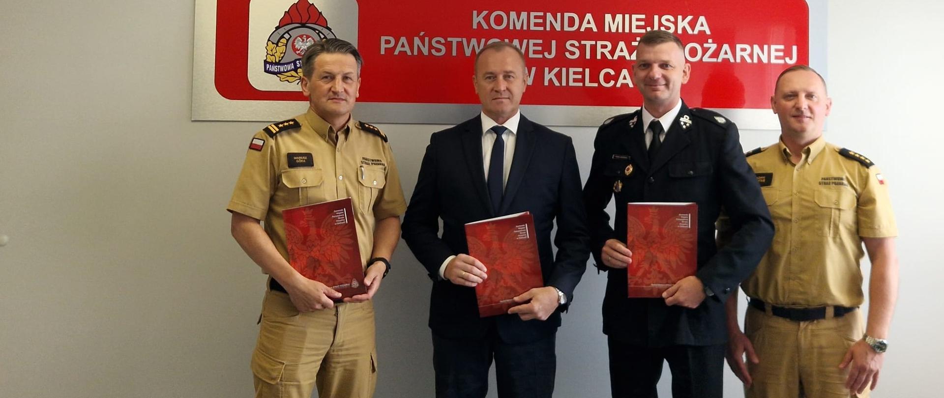 Zdjęcie przedstawia uczestników wydarzenia: od lewej: Komendant Miejski Państwowej Straży Pożarnej w Kielcach st. bryg. Mariusz Góra, Wójt Gminy Górno pan Przemysław Łysak, Prezes OSP Bęczków dh Karol Kędzierski i Zastępca Naczelnika Wydziału Operacyjno-Szkoleniowego st. kpt. Adam Kotaś 