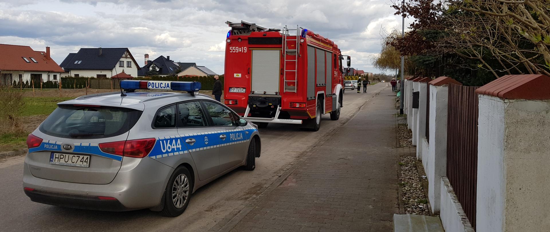 Na zdjęciu widnieje pojazd straży pożarnej i Policji w trakcie działań zabezpieczających znaleziony ładunek wybuchowy. 