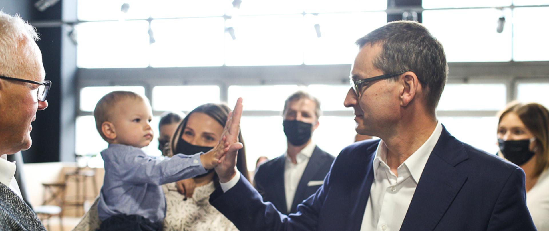 Premier przybija piątkę dziecku.