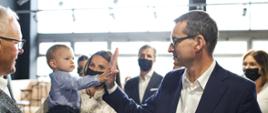 Premier przybija piątkę dziecku.
