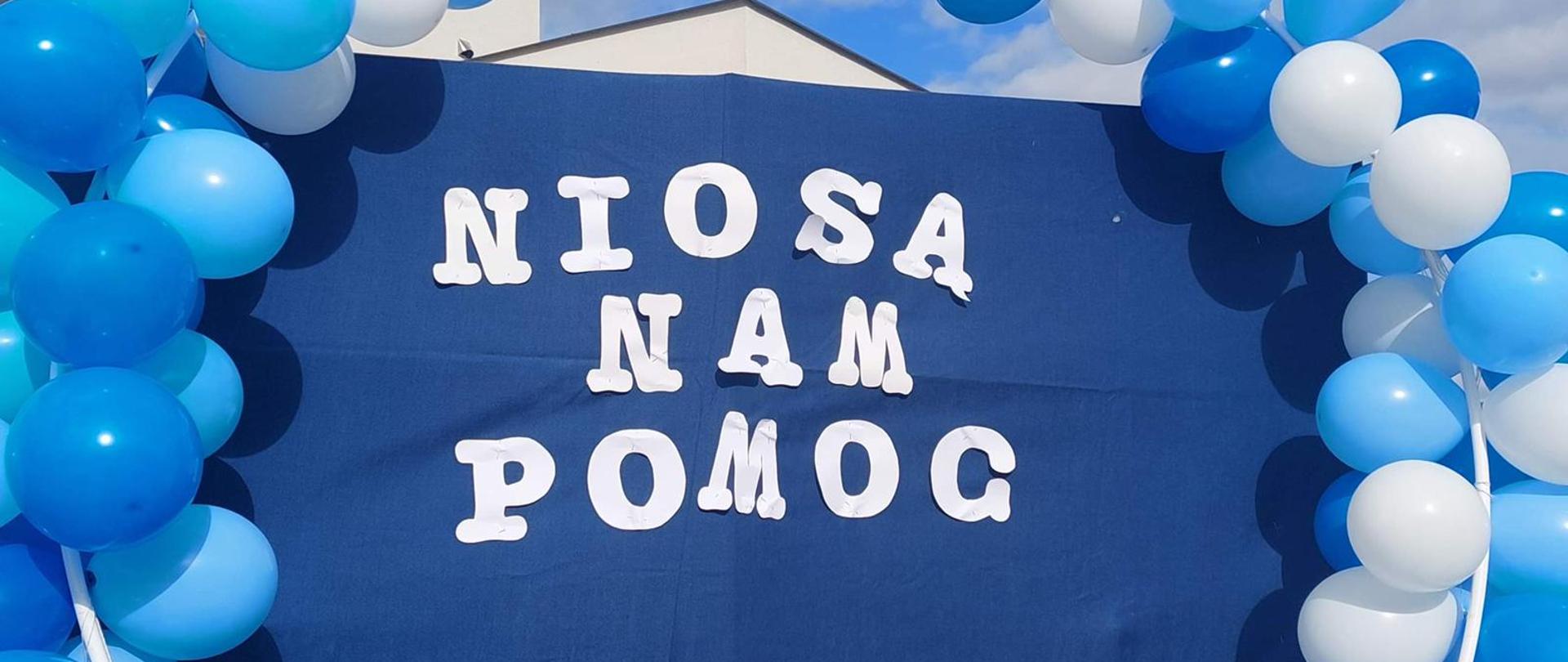 Zdjęcie przedstawia napis "Niosą nam pomoc" otoczony biało-niebieskimi balonami.