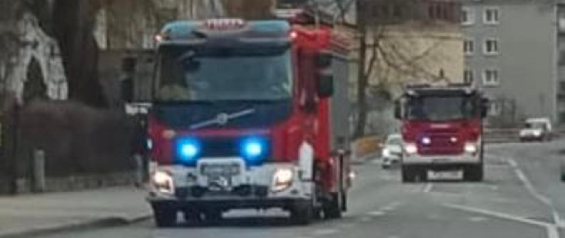 Na zdjęciu znajdują się samochody pożarnicze jadące alarmowo drogą
