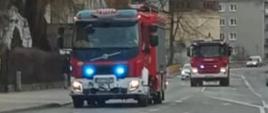 Na zdjęciu znajdują się samochody pożarnicze jadące alarmowo drogą