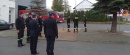 strażacy wciągają flagę na maszt 