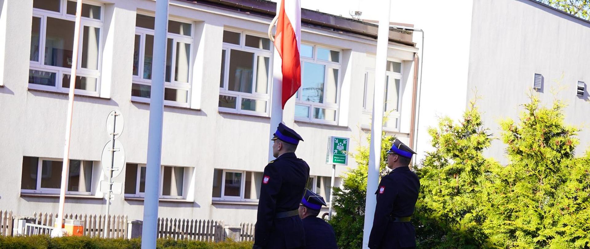 Strażacy podnoszą flagę na maszt