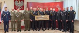 Na zdjęciu widoczny bryg. Maciej Wolański trzymający otrzymaną szablę z okazji przejścia na zaopatrzenie emerytalne pozujący do zdjęcia wraz z bryg. Przemysławem Przęczkiem Zastępcą Komendanta Wojewódzkiego PSP oraz Komendantami Powiatowymi i Miejskimi PSP z województwa małopolskiego wraz z przedstawicielami innych służb 