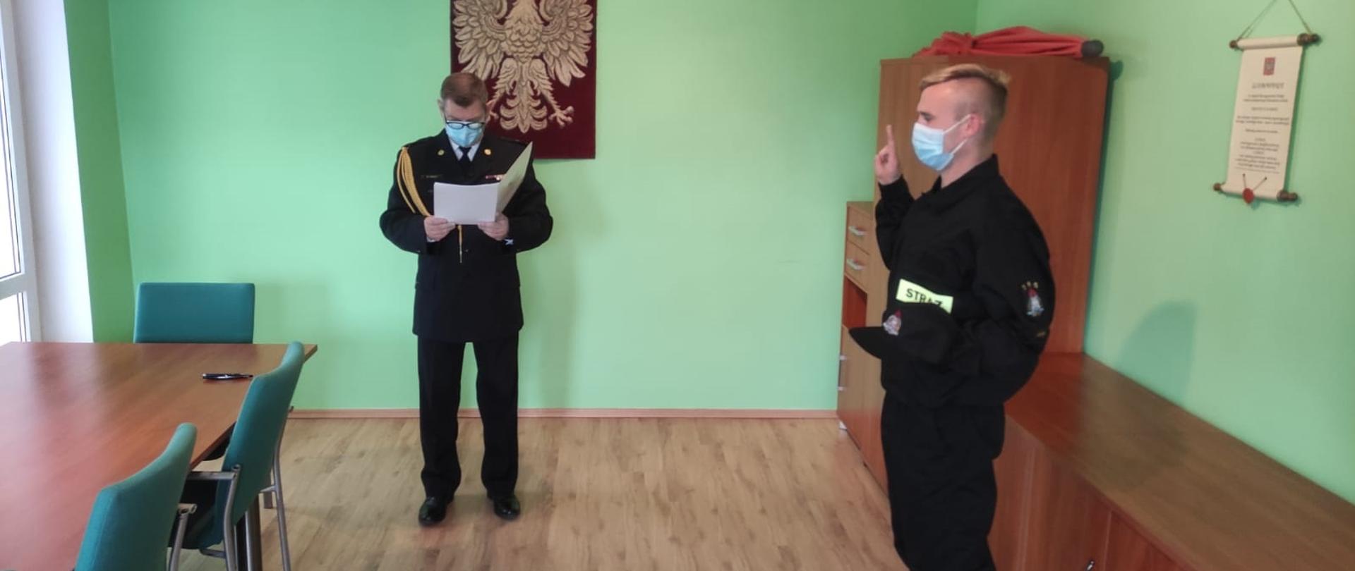 Obraz przedstawia strażaka składającego uroczyste ślubowanie. 