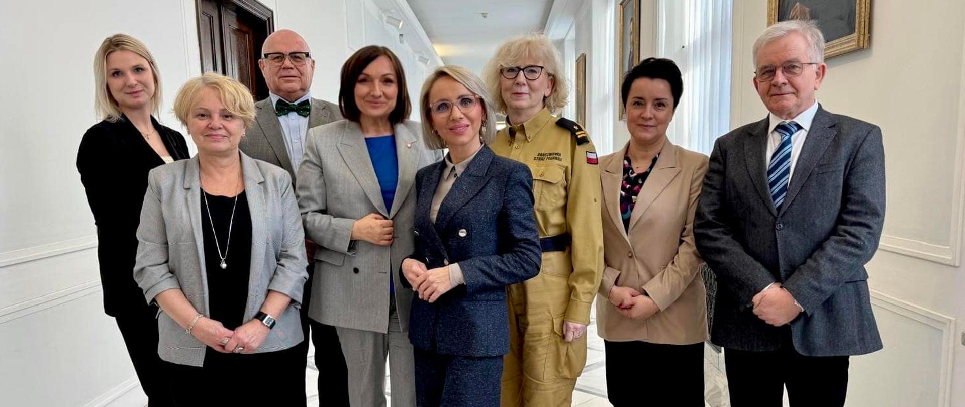 Osoby pozujące do zdjęcia na sejmowym korytarzu