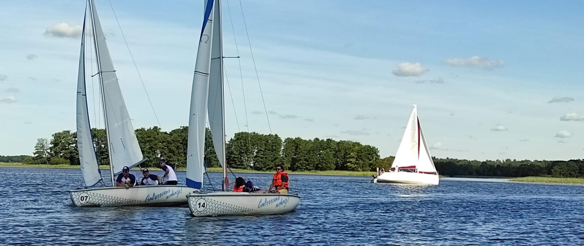 Żeglarze na jachtach pływają po jeziorze