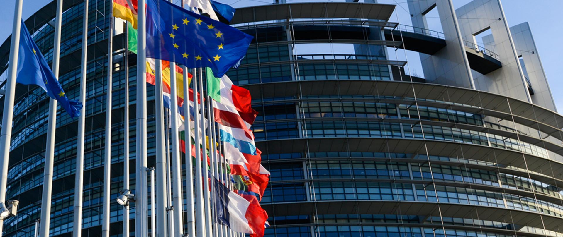 Budynek Parlamentu Europejskiego i stające przed nim flagi państw Unii