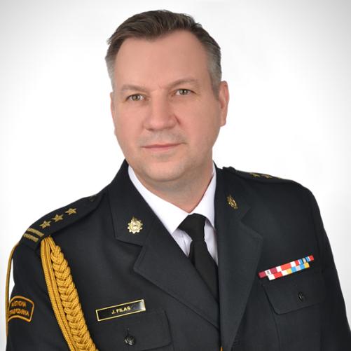 Zdjęcie portretowe przedstawia komendanta powiatowego PSP w Wodzisławiu Śląskim st. bryg. Jacka Filasa w mundurze wyjściowym ze sznurem galowym