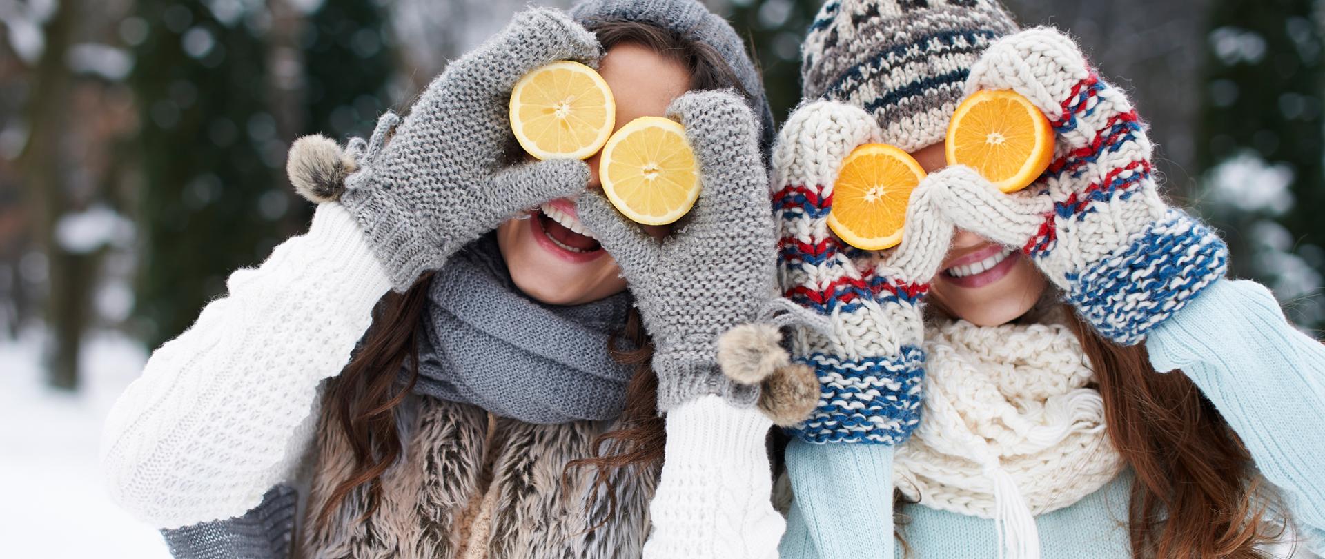 Zdjęcie przedstawia dwie kobiety w zimowej scenerii.
