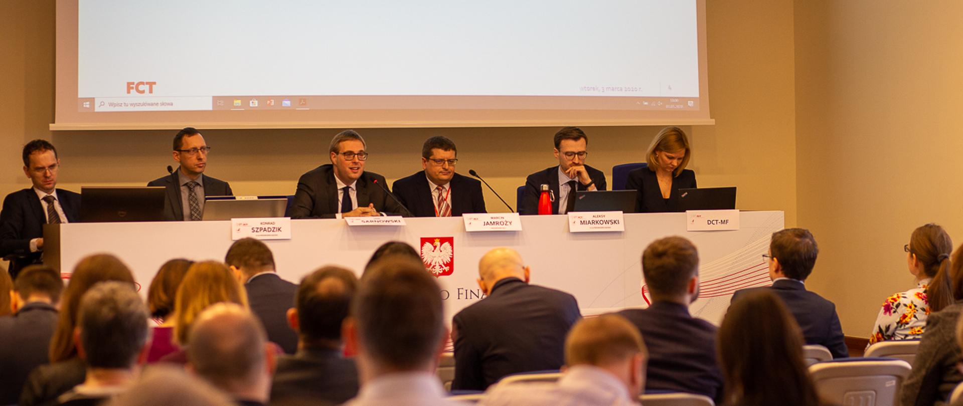 Minister Jan Sarnowski w otoczeniu swoich współpracowników przemawia uczestników Forum Cen Transferowych