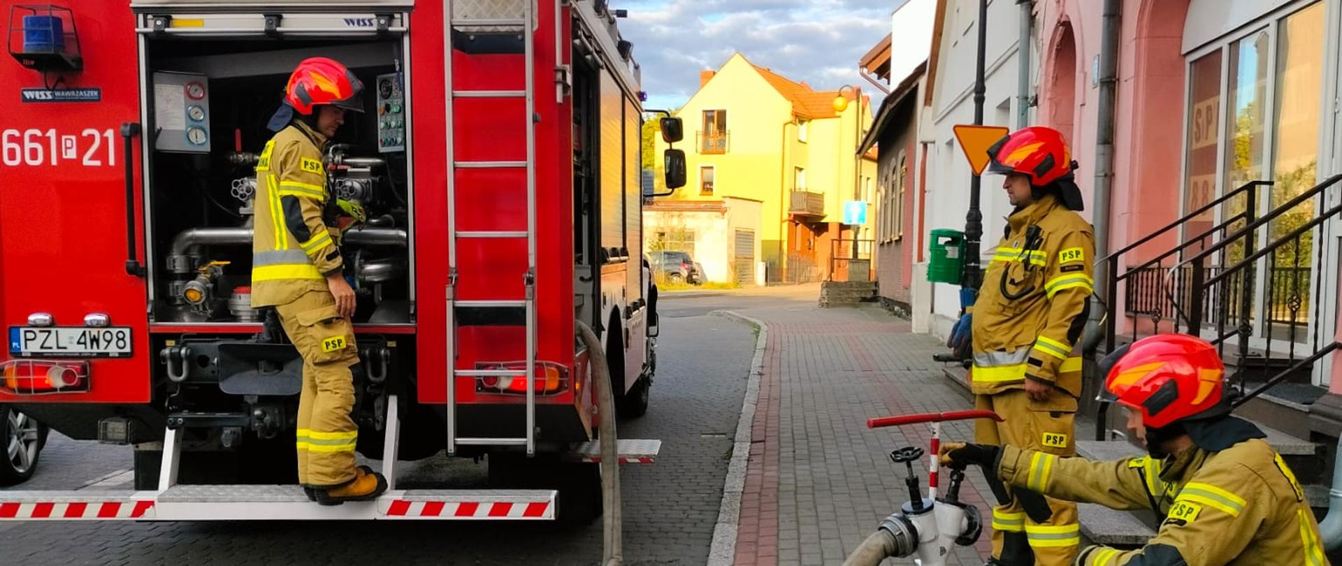 Na zdjęciu samochód strażacki oraz strażacy
