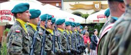 Grupa żołnierzy stojąca na placu przed urzędem miasta